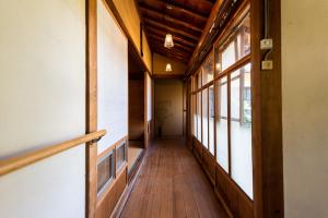a hallway with wooden floors and windows in a building at Hostel 東風ノ家（Kochi-no-ya） in Aki