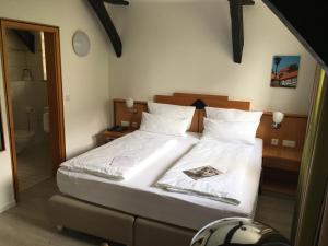 Schlafzimmer mit einem Bett mit weißer Bettwäsche und Kissen in der Unterkunft Alt Warburg in Warburg