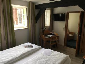 Schlafzimmer mit einem Bett, einem Schreibtisch und einem Fenster in der Unterkunft Alt Warburg in Warburg