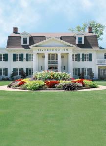 a large white house with flowers in front of it at Riverbend Inn & Vineyard in Niagara on the Lake