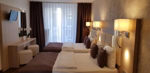 ein Hotelzimmer mit 2 Betten und einem TV in der Unterkunft Hotel Budapester Hof in Hamburg