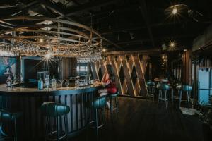 a woman sitting at a bar in a restaurant at The Malibu Hotel in Vung Tau