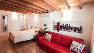 a living room with a red couch and a bed at B&B ai Musei in Brescia