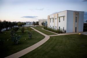 a building in a grassy field next to a building at Arthotel & Park Lecce in Lecce