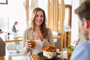 a woman sitting at a table with a drink at Strandgut Resort in Böhl +24 photos