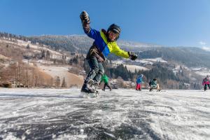 a person riding a snowboard on a snow covered slope at Feichterhof in Bad Kleinkirchheim