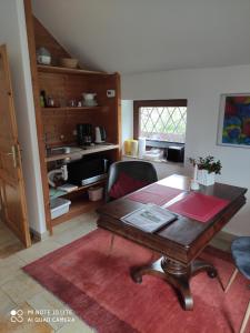 a living room with a wooden table and a kitchen at Hamburg-Rahlstedt, klein aber sehr fein, ILS-nah in Hamburg