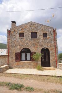 - un bâtiment en pierre avec deux fenêtres et une porte dans l'établissement ΕΥμορφο σαν παραμύθι ΑΜΥΓΔΑΛΙΑ, à Amfikleia