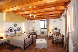 1 Schlafzimmer mit 2 Betten und Holzdecke in der Unterkunft Serravalle Relais & Country Villa with private pool - Esclusive use in Chiaramonte Gulfi