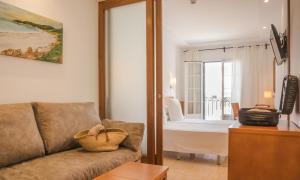een woonkamer met een bank en een balkon bij Hotel Jeni & Restaurant in Es Mercadal