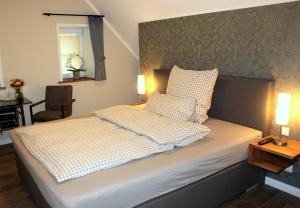 ein Schlafzimmer mit einem Bett mit zwei Kissen darauf in der Unterkunft DZ/EZ Lodberger Scheunencafe in Löningen