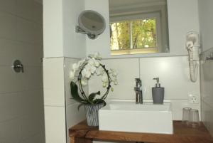 La salle de bains est pourvue d'un lavabo et d'un miroir. dans l'établissement DZ/EZ Lodberger Scheunencafe, à Löningen