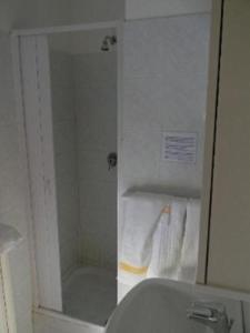 a bathroom with a shower and a sink and a mirror at Hotel Giampy in Assergi