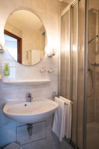 La salle de bains est pourvue d'un lavabo et d'un miroir. dans l'établissement Pension am Heusteig, à Stuttgart