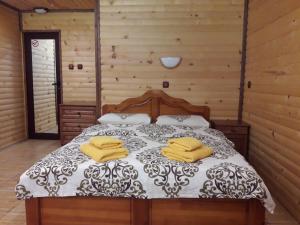 Un dormitorio con una cama con toallas amarillas. en Guest House Chobaka en Trigrad