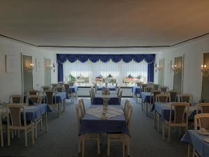 une salle à manger avec des tables et des chaises bleues dans l'établissement Hotel Garni La mer, à Bad Zwischenahn