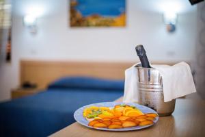 a plate of fruit on a table next to a juicer at Arcomagno Beach Resort in San Nicola Arcella