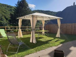 a gazebo with a table and chairs in a yard at LA MAISON DE JADE in Soursac