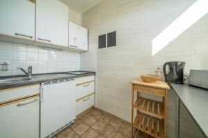 une cuisine avec des placards blancs et un comptoir dans l'établissement Private Apartment, à Hanovre