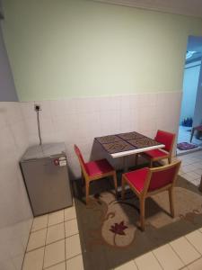 a kitchen with a table and two chairs and a stove at Cikgu Azue Homestay in Ampang