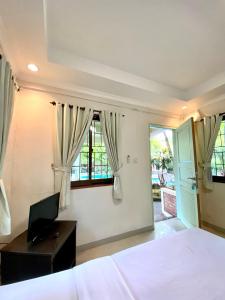 a bedroom with a bed and a desk and windows at New Green Sentul Resort in Bogor