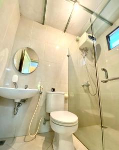 a bathroom with a toilet and a sink and a shower at New Green Sentul Resort in Bogor