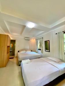 a hotel room with two beds and a bathroom at New Green Sentul Resort in Bogor