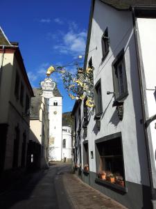 an alley with a building and a clock tower at Hotel Weinhaus Am Stiftstor in Treis-Karden