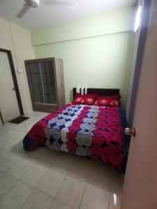 Un dormitorio con una cama con una colcha colorida. en Cikgu Azue Homestay en Ampang