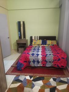 安邦的住宿－Cikgu Azue Homestay，一间卧室,床上有五颜六色的被子