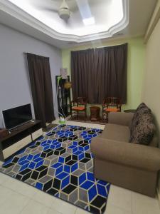 uma sala de estar com um sofá e piso em azulejo em Cikgu Azue Homestay em Ampang