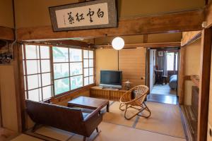 a living room with a couch and a television at Hostel 東風ノ家（Kochi-no-ya） in Aki