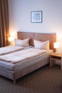 two beds in a hotel room with two lamps at Pension am Heusteig in Stuttgart