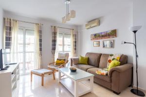 ein Wohnzimmer mit einem Sofa und einem Tisch in der Unterkunft Victoria 50 in Málaga