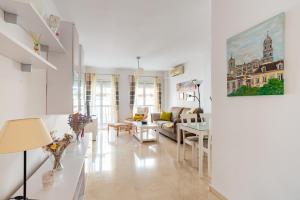 ein weißes Wohnzimmer mit einem Sofa und einem Tisch in der Unterkunft Victoria 50 in Málaga