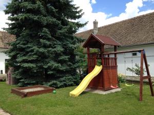 a playground with a slide and a gazebo at Varázsfészek Vendégház in Majs