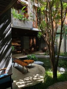 a bench in front of a building with a pond at Minh Boutique in Danang