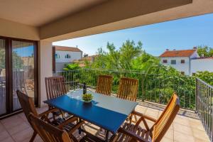 d'un balcon avec une table et des chaises bleues. dans l'établissement DAMIR 4+1+1, à Crikvenica