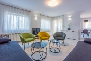 - un salon avec des chaises colorées et un canapé dans l'établissement DAMIR 4+1+1, à Crikvenica