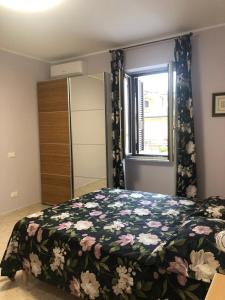 una camera da letto con un letto con copriletto floreale di B&B Antonella a Monterotondo