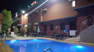 uma piscina em frente a um hotel à noite em Hôtel Ajil Cascades D'ouzoud em Ouzoud