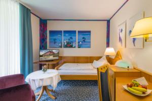 a hotel room with a bed and a table at Eden Hotel in Bad Krozingen