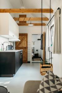 a kitchen with white cabinets and a black counter top at Relaxed eigen plekje in de Peel - Kostelijk in Helenaveen