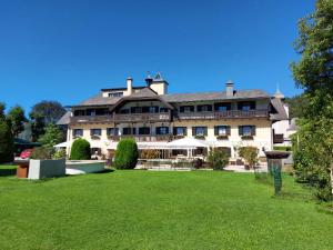 um grande edifício com um relvado em frente em Hotel Stroblerhof em Strobl