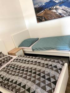 two beds in a room with a checkered floor at Apartmán Mladé Buky in Mladé Buky