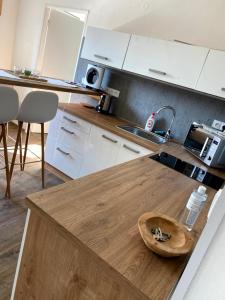 a kitchen with white cabinets and a wooden counter top at Apartmán Mladé Buky in Mladé Buky