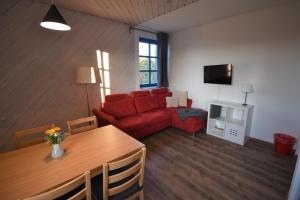 sala de estar con sofá rojo y TV en Beerenvilla, en Kurort Altenberg