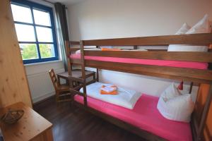 2 łóżka piętrowe w pokoju ze stołem w obiekcie Beerenvilla w mieście Altenberg