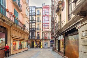 een lege straat in een stad met hoge gebouwen bij Casco Viejo junto a la Plaza Nueva y Unamuno in Bilbao