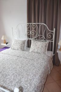 1 dormitorio con cama blanca y cabecero de metal en Baou House 1, en Metsovo